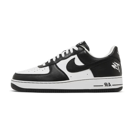 Lateral profile view of the Nike Air Force 1 Low QS Terror Squad Blackout sneaker featuring a white leather mid-panel and toe box, black leather overlays, white "TS" logo embroidery on the lateral heel, white midsole, and black rubber outsole.