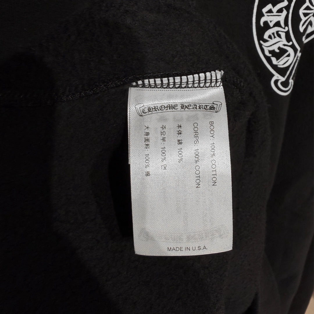 Close-up of the Chrome Hearts tag on the black Miami Exclusive Hoodie.